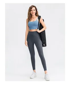 Detail view of high-waist grey yoga leggings with a blue sports bra and yoga mat bag