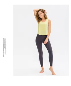Women's pale yellow loose yoga vest paired with charcoal grey high waist leggings set