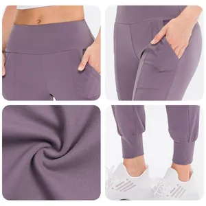 Detailansicht von hohem Bund, Seitentaschen und Rippbündchen an lila Yoga-Hosen