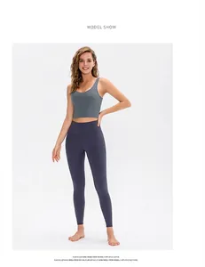 Model wearing grey U-neck sports bra and high-waisted purple yoga leggings set