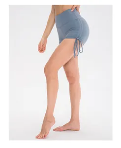 Detail view of high-waisted blue-grey yoga shorts with side drawstring and ruched texture