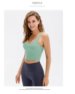 Détail d'un haut de yoga vert clair à col en U et d'un legging de sport gris foncé