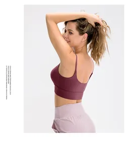 Detail view of burgundy racerback sports bra with cross straps and pink yoga leggings