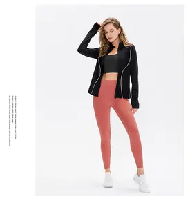 Detail of black zip-up sports jacket with coral red high-waist yoga leggings and sneakers