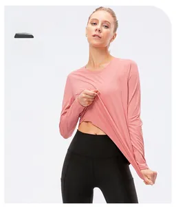 Detail of pink long sleeve yoga top with side slit and black high waist leggings
