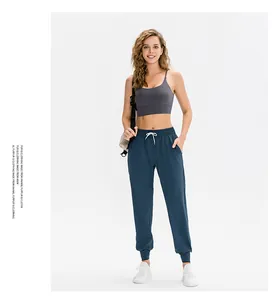 Detail of gray racerback sports bra with high-waist joggers and white sneakers