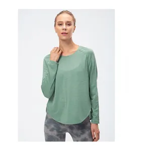 Détail de la fente latérale et de l'ourlet arrondi sur le haut de yoga vert haricot