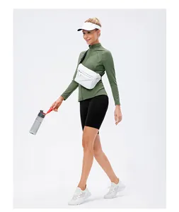Women's army green zip-up yoga jacket with cycling shorts and crossbody bag outfit