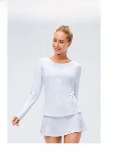 Détail d'un haut de sport blanc à manches longues et d'une jupe de sport plissée