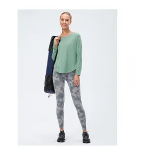 Détail d'un t-shirt de sport ample avec fente latérale et legging de yoga effet tie-dye