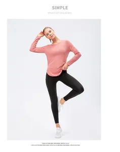 Detail of pink long-sleeve yoga top with curved hem and black leggings set