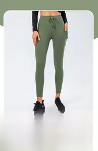 Detail of high-waist dark green yoga pants with drawstring and functional side pockets