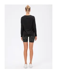 Vue de dos d'une femme en haut de sport noir et short de cyclisme camouflage vert