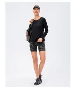 Vue de face d'une femme en haut thermique noir et short de fitness camouflage