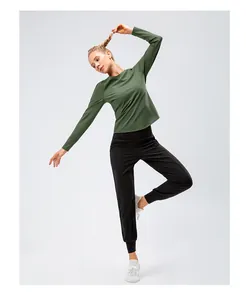 Détail du haut thermique vert extensible et du jogging noir pour le yoga et le fitness