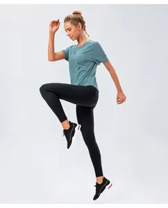 Detail of teal raglan short sleeve t-shirt and high waist black yoga leggings with pockets
