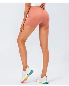 Detail view of high-waisted yoga shorts in coral pink with side pocket functionality