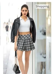 Detail of high waist black and white plaid pleated mini skirt paired with a leather jacket