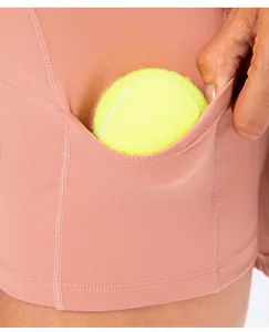 Detail of high-stretch dusty rose yoga shorts featuring a functional side pocket for tennis ball