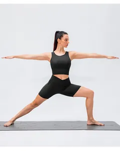 Dettaglio del set yoga con pantaloncini a vita incrociata e reggiseno sportivo su tappeto