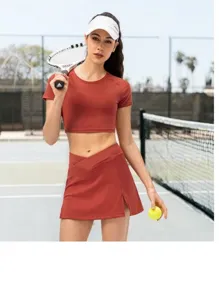 Detail of high-waist slit tennis skirt and cropped top in breathable red clay fabric