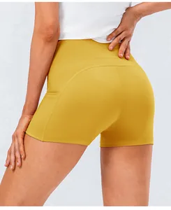 Close-up of curved stitching on high-waist ginger yellow athletic yoga shorts for women