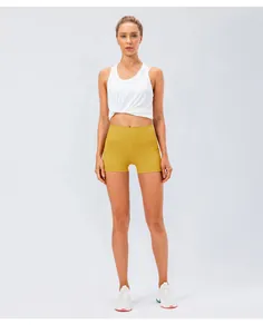 Detail of yellow high-waisted yoga shorts paired with a white knotted sports top