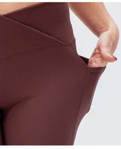Dettaglio degli shorts da yoga a coste da donna con vita alta incrociata e tasca laterale