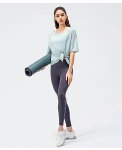 Detail van lichtblauwe yogatop met zijknoop en paarse legging met hoge taille