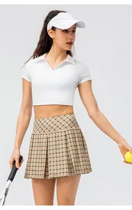 Vista detallada de polo deportivo para mujer con falda de tenis plisada y visera
