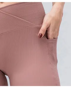 Dettaglio dei pantaloncini da yoga con vita incrociata e tasca laterale rosa loto