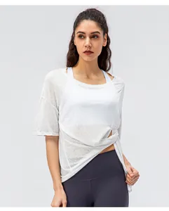 Detail van witte sneldrogende sporttop met een zijdelingse knoop en ademende stof