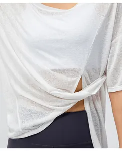 Detail van witte sneldrogende sporttop met tailleknoop en lichte functionele stof