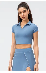 Detalle de polo corto azul grisáceo con cuello en V y falda a juego con ribete blanco
