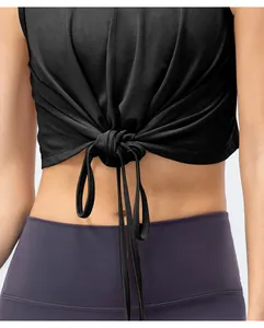 Détail du haut court de sport noir avec nœud et legging de yoga à taille haute
