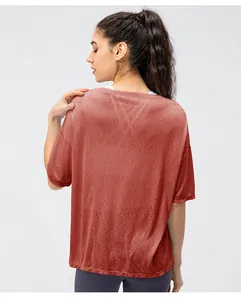 Detail van de ademende stof en split aan de achterkant van het rode sportshirt