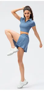 Detail van blauwe polo crop top en sportieve skort set gemaakt van elastische sportstof
