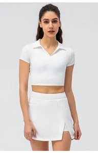 Detail von weißem Polo-Crop-Top und Tennisrock mit Seitenschlitz und hochelastischem Stoff