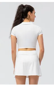 Rückansicht des weißen schmal geschnittenen Polo-Tops und des hohen Sportrocks für Damen