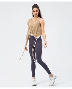 Détail d'un débardeur de yoga marron avec cordons latéraux et leggings violets
