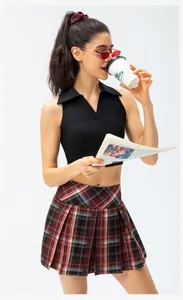 Detail van zwarte mouwloze polotop en een rode geruite geplooide mini-rok set