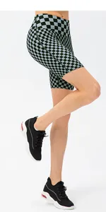 Detail of high-waist checkerboard biker shorts showing the elastic fabric fit on a model