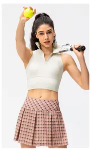 Detail van wit slank polo yoga vest en roze geruite geplooide tennisrok voor dames