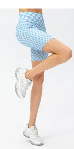 Blue and white checkered high waist yoga shorts shown on model with white sneakers