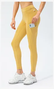 Detail of high waist yoga pants featuring a side pocket and waist buckle in yellow