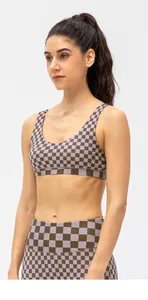 Detail of checkered sports bra set with wide straps and high-waist yoga leggings