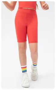 Detail of coral red high-waist kids athletic shorts showing stretch fit for running