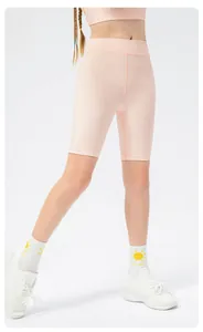 Detailed view of peach pink kids high-waisted yoga shorts with soft matte texture fabric