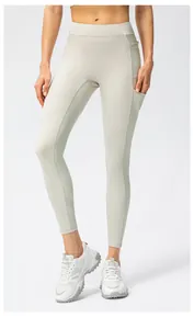 Close-up of high-waisted yoga pants with side pockets in beige color for women