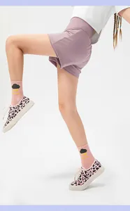 Close-up of girls sports shorts with leopard print sneakers and colorful designer socks